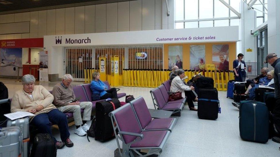 Passengers outside a Monarch Airlines customer service office at Manchester airport