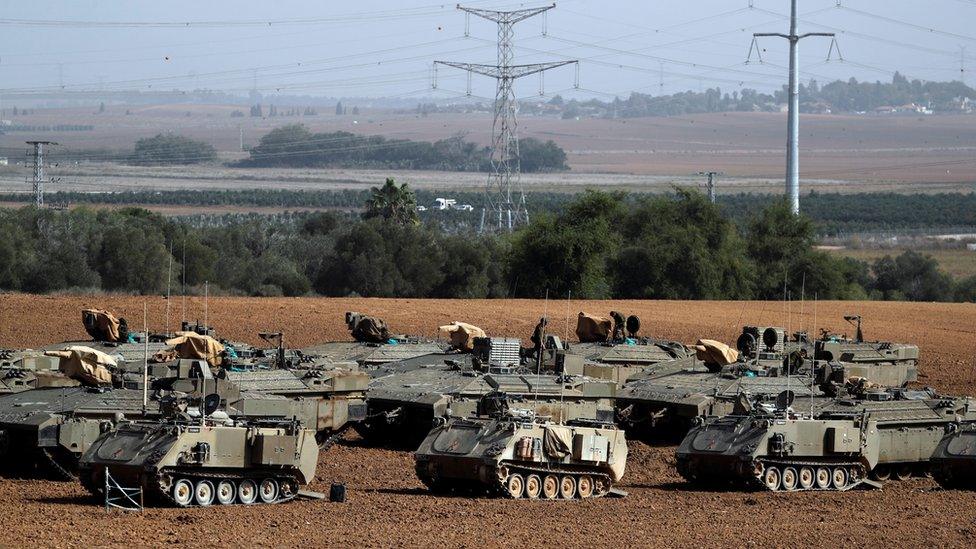 Israeli soldiers stand on armoured personnel carriers near the border with Gaza (13 November 2019)