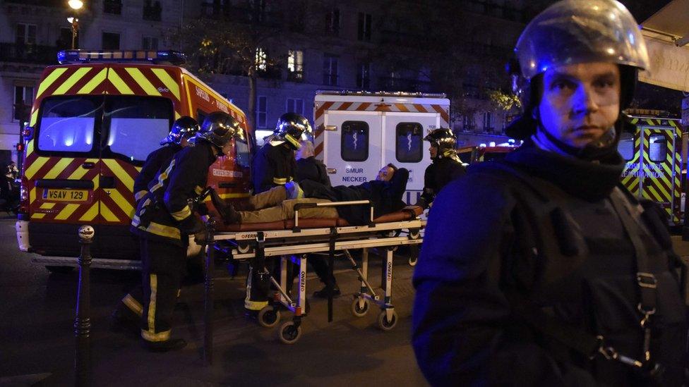 Rescuers workers evacuate a man on a stretcher near the Bataclan concert hall in central Paris, on November 13, 2015