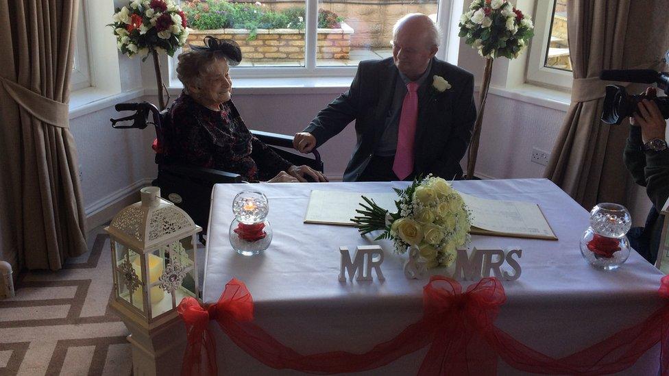 The newlyweds at a table with a sign saying "Mr & Mrs"