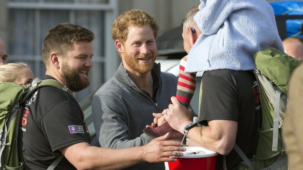 Prince Harry greeting a participant of the charity event "Walking with the Wounded" at Buckingham Palace