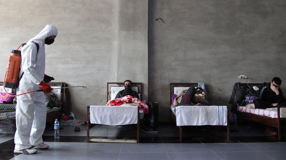 A man sanitises the room as Syrians who returned from Turkey rest at a quarantine facility in the countryside of the town of Jisr al-Shughur, west of the mostly rebel-held Syrian province of Idlib, 27 April 2020