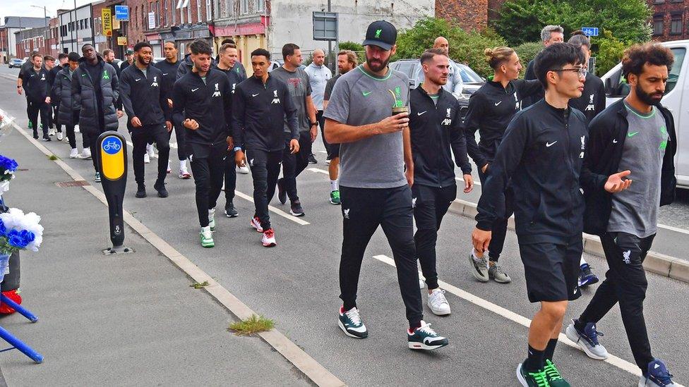 Liverpool players walk past the tributes at Bramley-Moore Dock