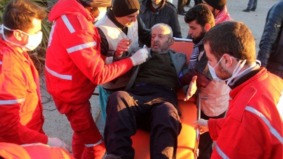 A wounded Syrian, who was evacuated from rebel-held neighbourhoods in the embattled city of Aleppo, is carried by aid workers upon his arrival in the opposition-controlled Khan al-Aassal region, west of the city, on December 15, 2016