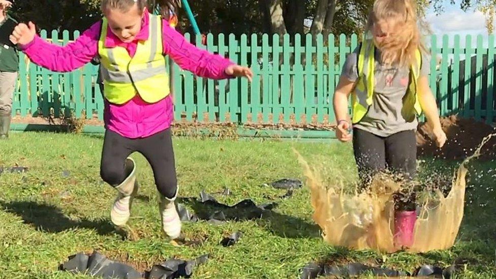 Children splashing in puddle