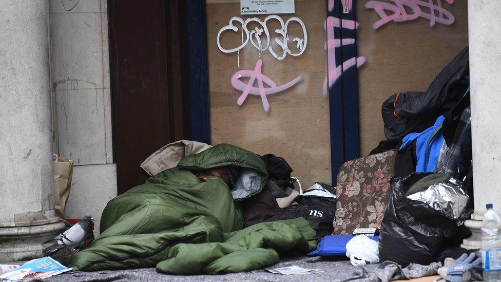 A homeless man sleeping in a doorway