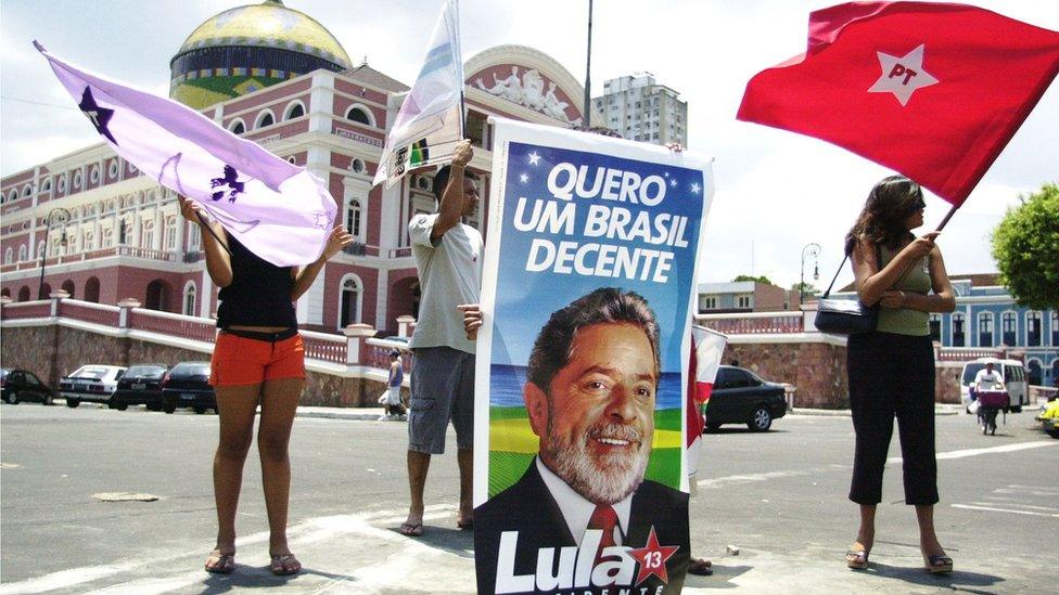 Supporters of Brazil's front-running presidential candidate Luiz Inacio Lula da Silva, of the Worker's Party (PT), wave flags in front of a famous Manaus theatre September 27, 2002 in Manaus, Brazil