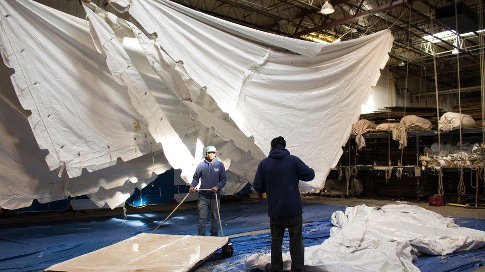 Workers wash the white tents after an event