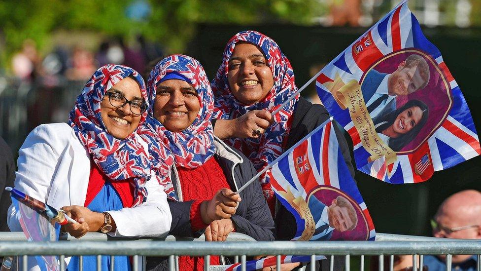 Three girls wearing Union Jack headscarves and waiving flags