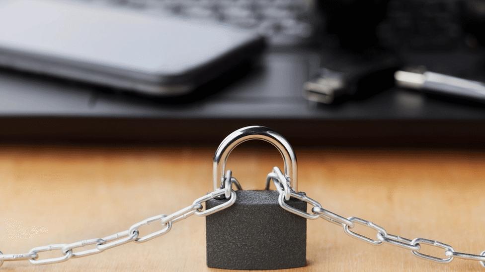 Padlock with devices in background