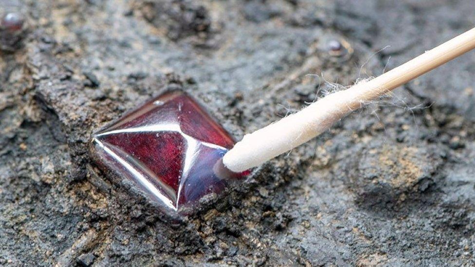 Archaeologist examining a garnet