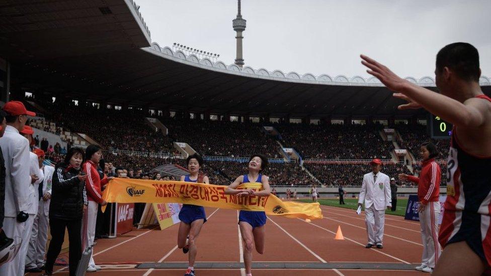 Kim Hye Gyong, right, narrowly beats her twin Kim Hye Song in the women's professional marathon