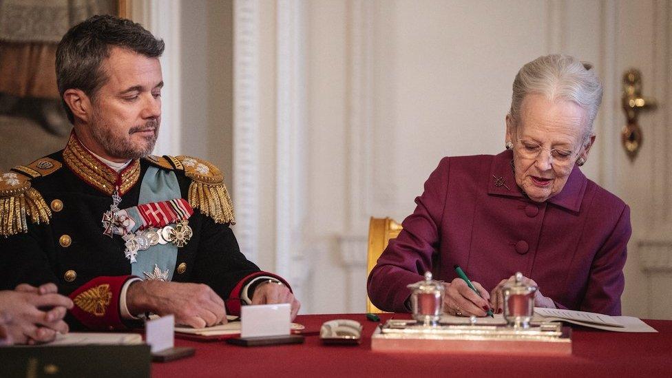 The crown prince watches as his mother, Queen Margrethe, signs the abdication papers