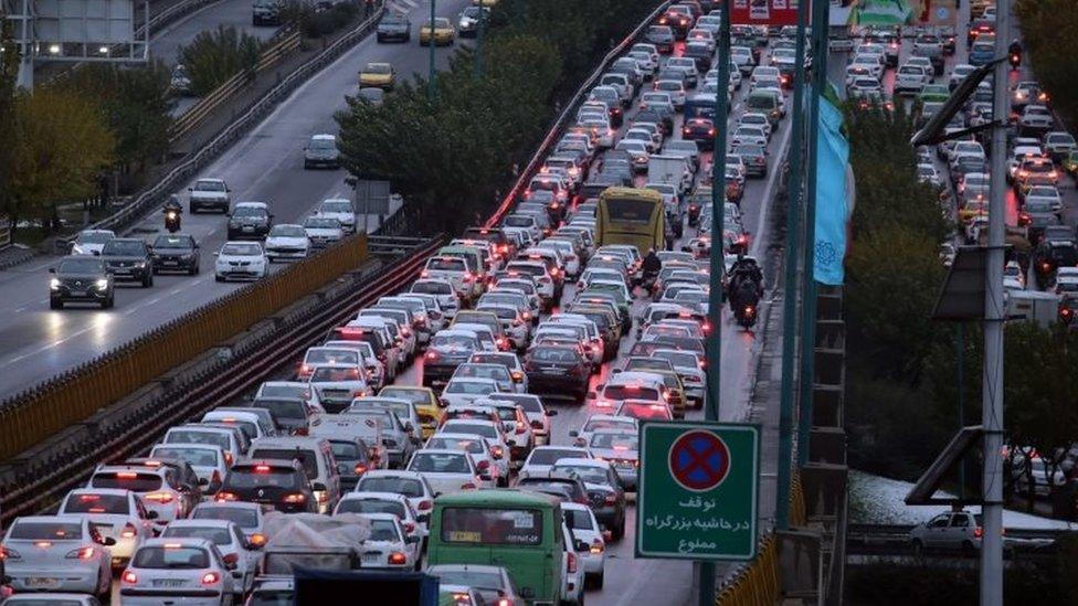 A highway is blocked by vehicles as protests block the roads following fuel price increase in Tehran, Iran