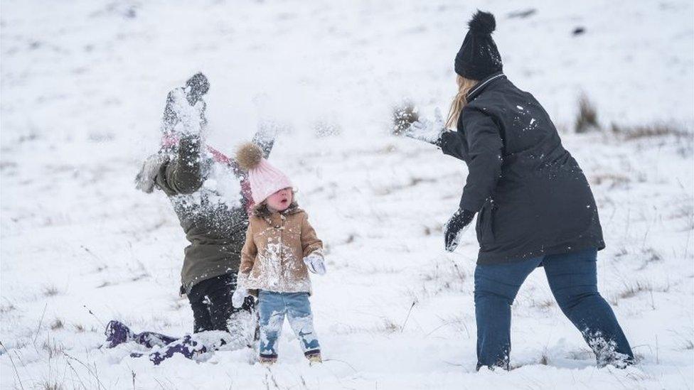 Families having snowball fights on the mountains at Brecon Beacons National Park, Wales