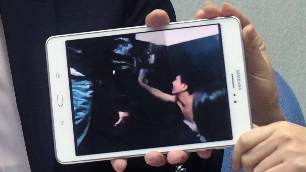 Johnny Chiang, a legislator from the Kuomintang (KMT) party, displays a video clip showing Taiwanese detained at a police station in Kenya, during a press conference at Parliament in Taipei on 12 April 2016