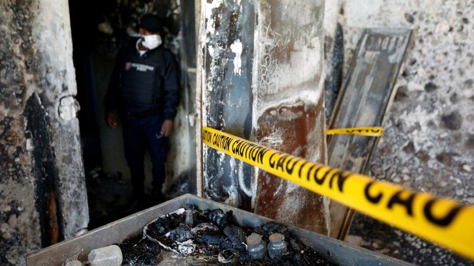 A police officer looks at burnt debris at an orphanage after it was partially destroyed in a fire, in Port-au-Prince, Haiti, 14 February, 2020