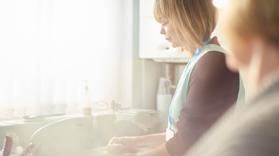 A care worker doing the washing up