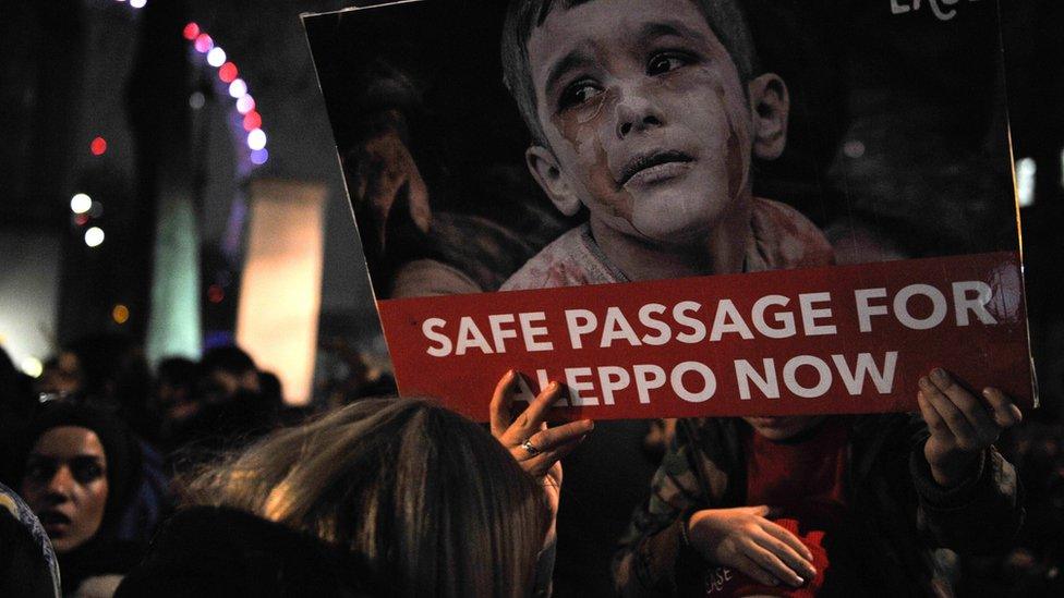 Protesters hold placards during a demonstration in solidarity with the inhabitants of the embattled Syrian city of Aleppo, outside the entrance to Downing Street