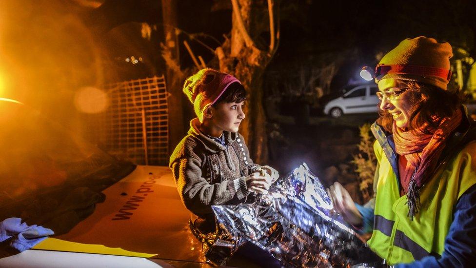 A child sits on a car in Lesbos