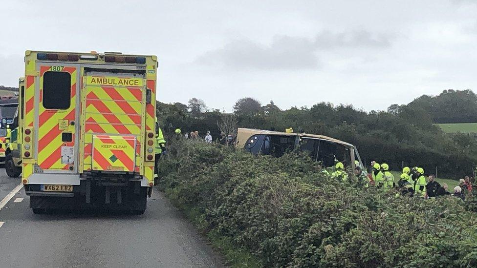 Overturned bus and ambulance.