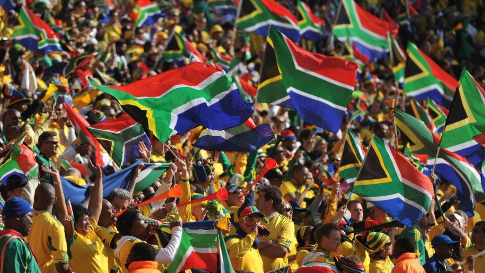 South Africa supporters wave national flags during the opening ceremony of the 2010 World Cup