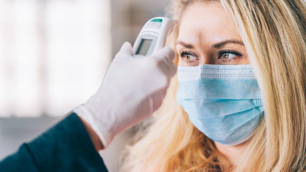 A woman having her temperature taken