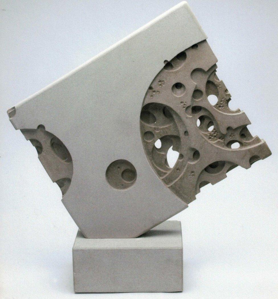 A sculpture of a block with many holes in it