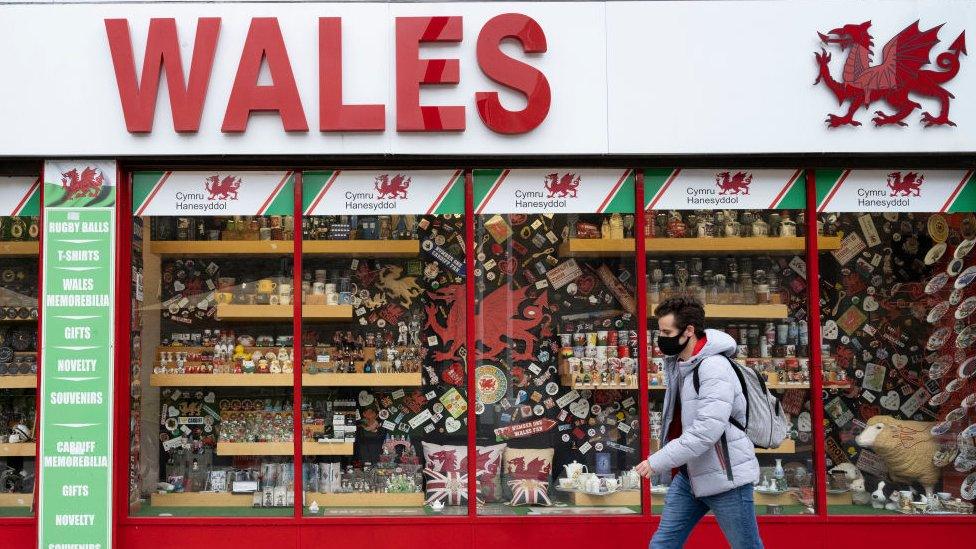 Man walking past shop in facemask