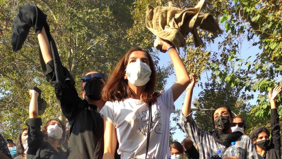 Women wave their headscarves in the air at a protest in Tehran, Iran (1 October 2022)