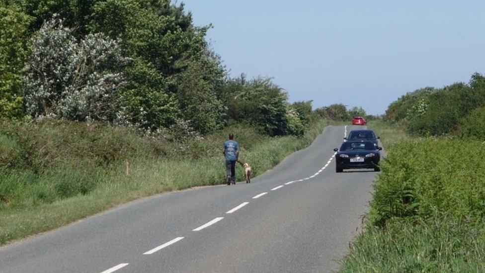 Man walking along busy road