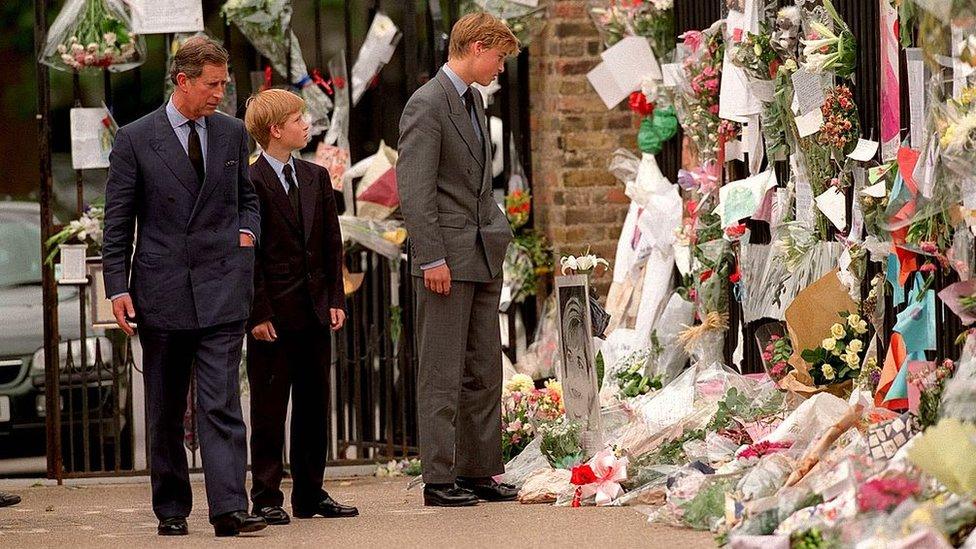 The Prince of Wales, Prince William and Prince Harry look at floral tributes to Diana, Princess of Wales outside Kensington Palace.