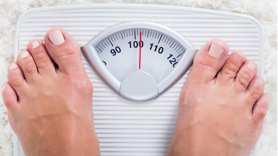 Woman standing on weighing scales