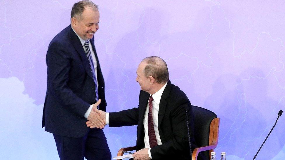 Vladimir Lisin (L) shaking hands with Russia's President Vladimir Putin (R) during a meeting of the Russian Union of Industrialists and Entrepreneurs in 2017