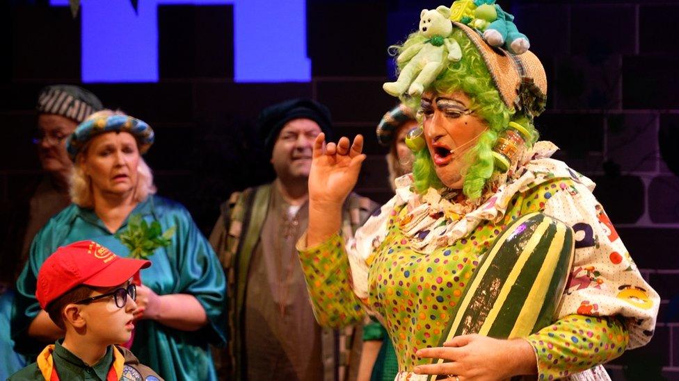 James Knight the pantomime dame holding a watermelon looking upset while other cast members look on