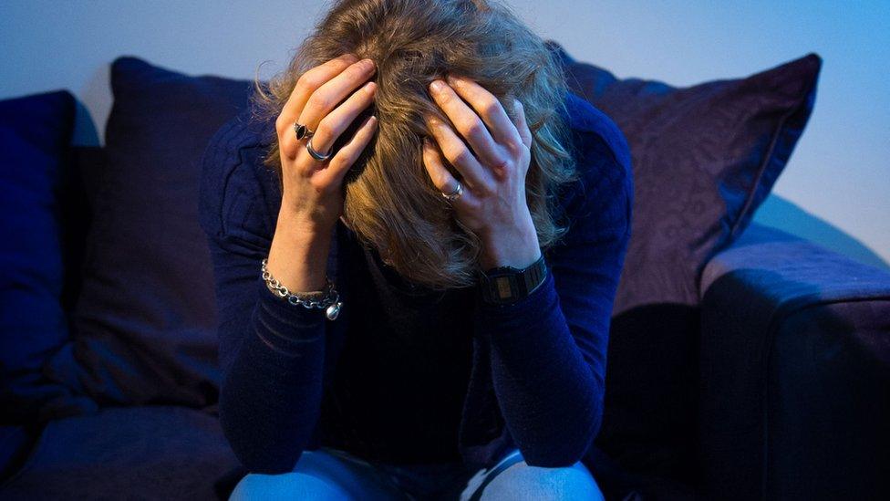 A woman holding her head in her hands