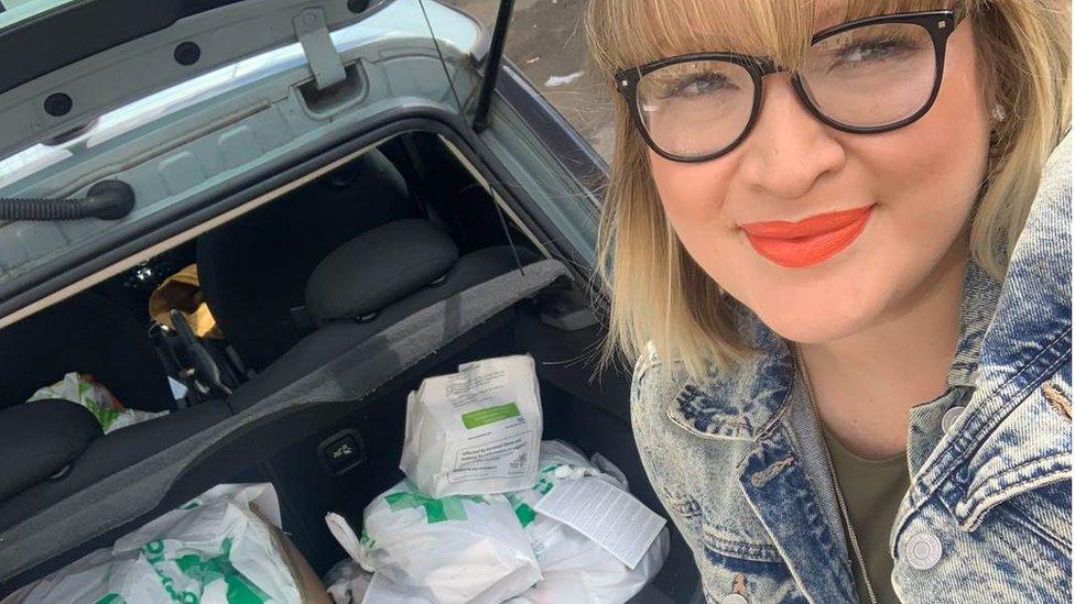 Liz is pictured in front of her car boot with medicines packed in for delivery