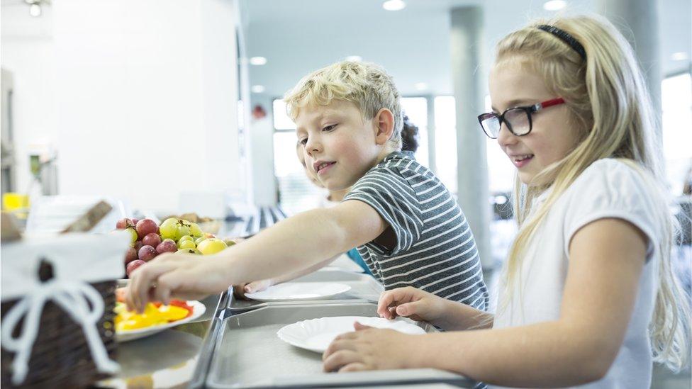 Two school children get their school dinners