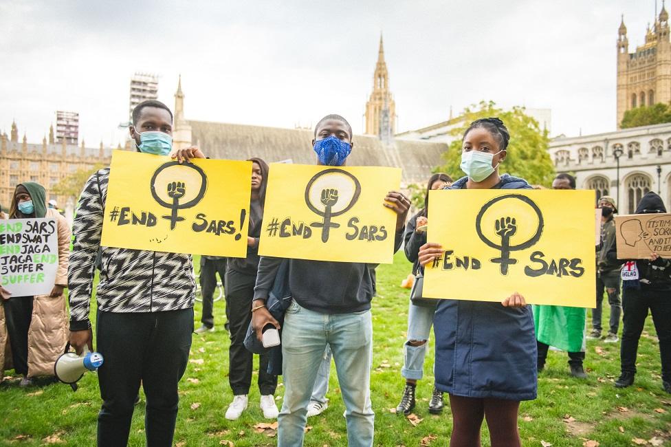 Protesters hold placards outside Parliament in London