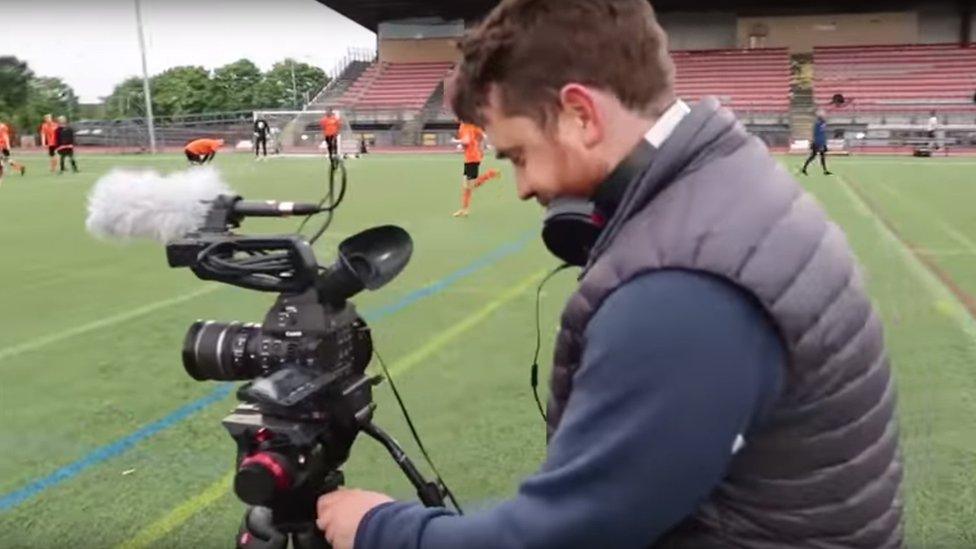 Camera crew setting up on pitch