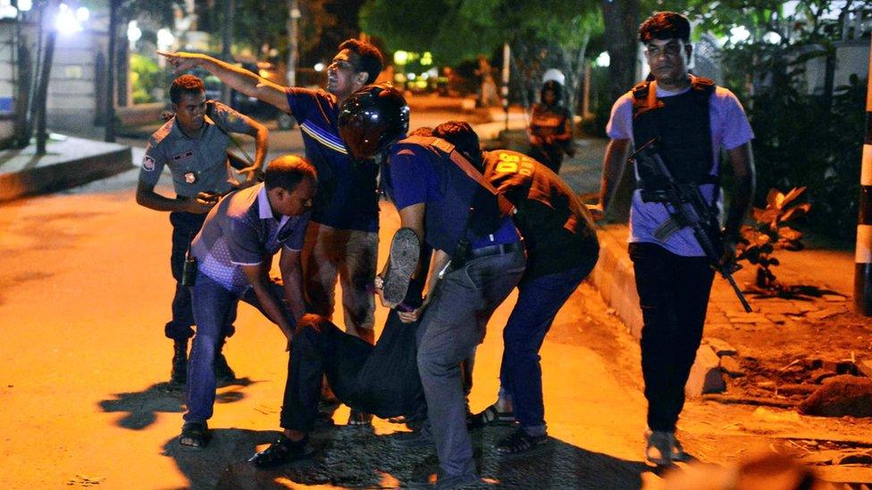 Police help an injured person during a siege in the Bangladeshi capital Dhaka