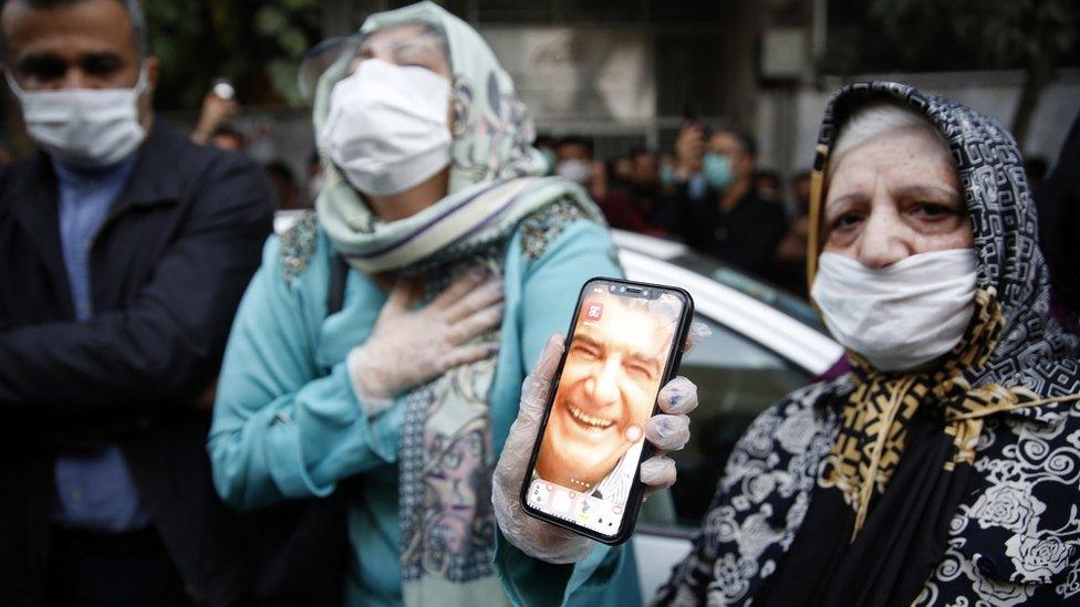 Female fans of Iran"s legendary singer, instrumentalist, and composer Mohammad-Reza Shajarian, holding pictures of him, as they mourn in front of the Jam hospital, where Shajarian reportedly passed away, in Tehran, Iran, 08 October 2020.