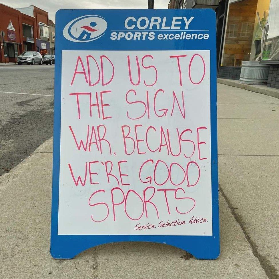 A sign from a sports shop reads 'add us to the sign war because we're good sports'