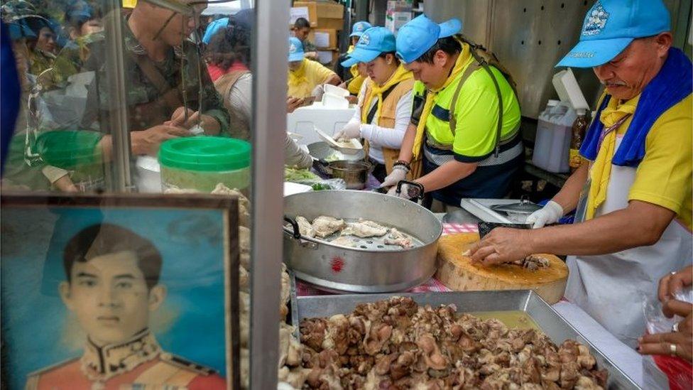 Volunteers prepare food for rescuers and family members outside the caves in Thailand on 5 July 2018