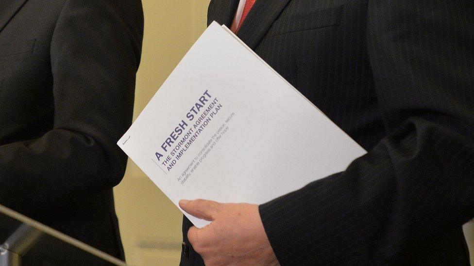 First Minister Peter Robinson holds a copy of A Fresh Start: The Stormont Agreement and Implementation Plan