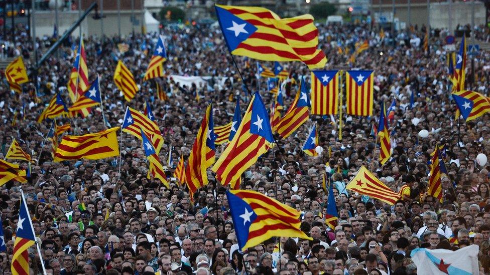 This file photo taken on September 25, 2015 shows people waving Catalan and Catalan independence flags (Estelada) during the Catalan independence coalition "Junts pel Si" (Together for the Yes) party"s final campaign meeting for the regional election, in Barcelona.