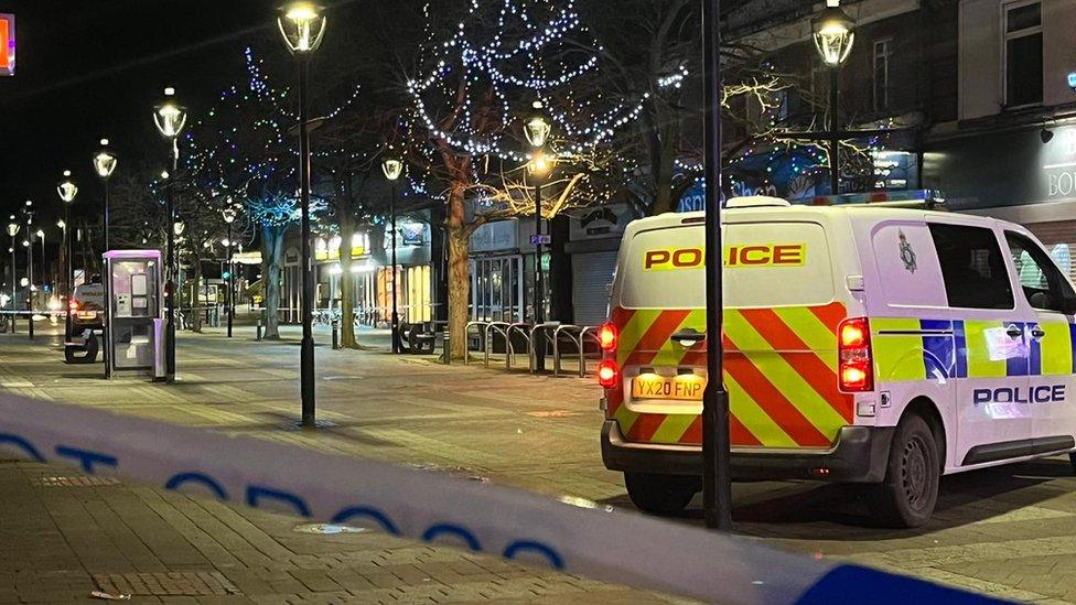 Police van parked on a pedestrian shopping street in Goole behind a cordon