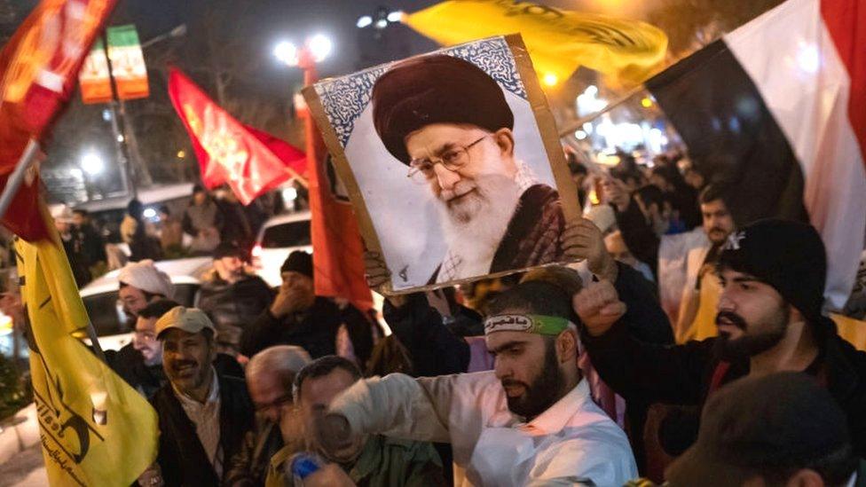 Protesters in Tehran in front of the British embassy carrying a Yemeni flag and portrait of the supreme leader