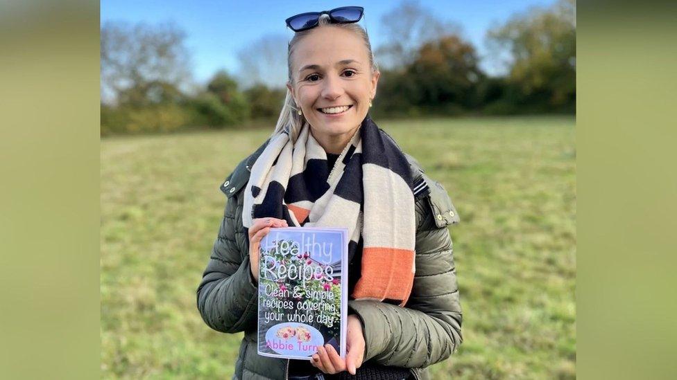 Abbie Turner holding cook book