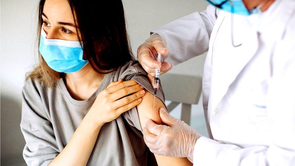 young woman being vaccinated